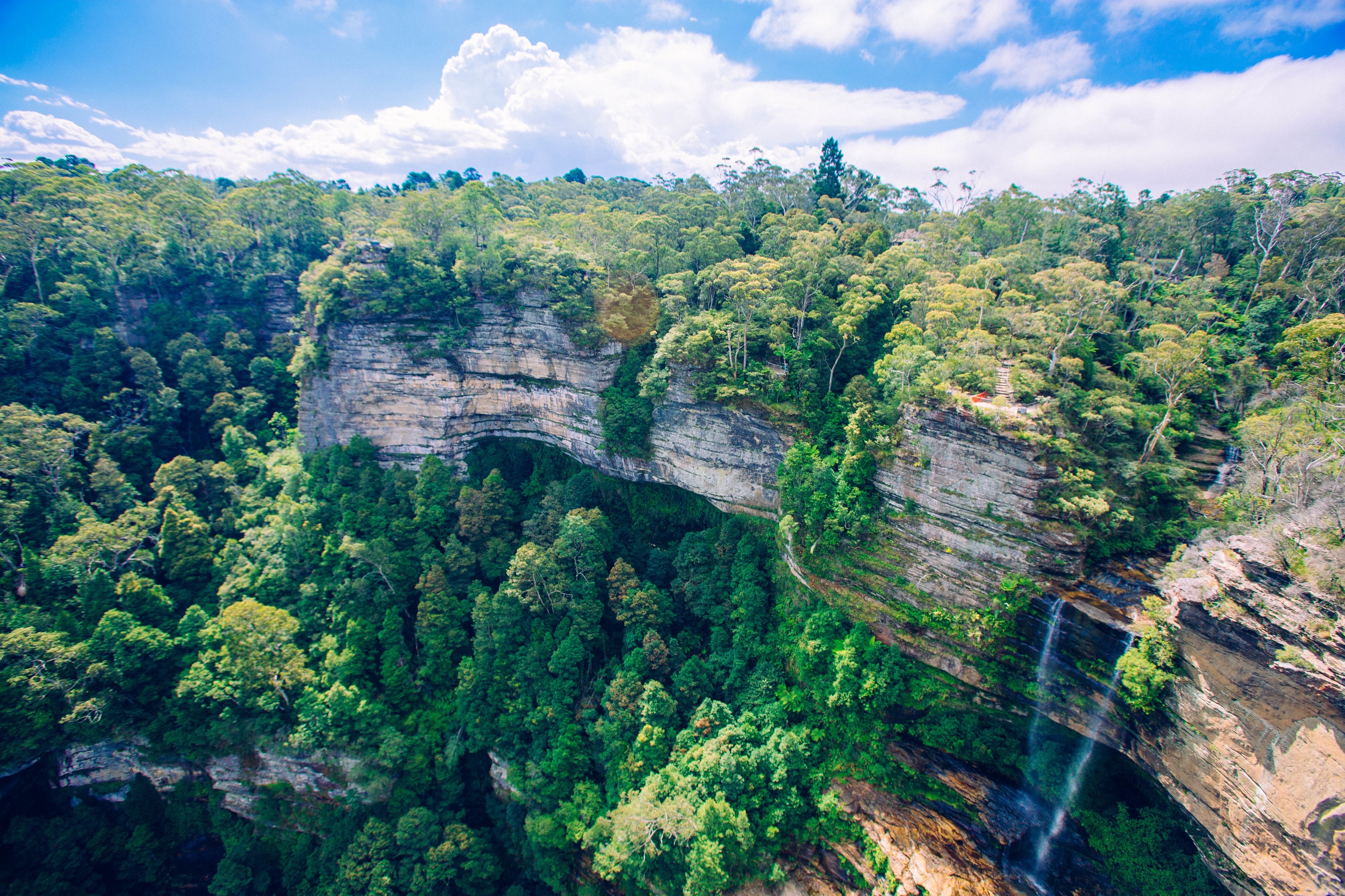 Felswand mit Bäumen und Wasserfall in Australien