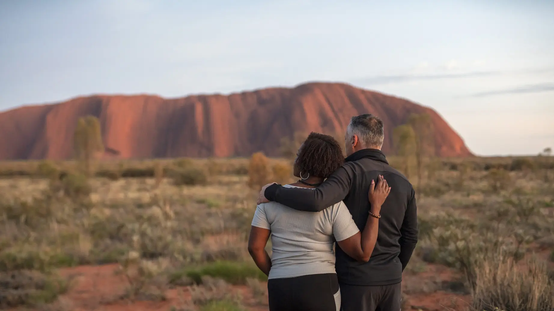 Ein Paar starrt in die Ferne im Uluru National Park, Northern Territory, Australien