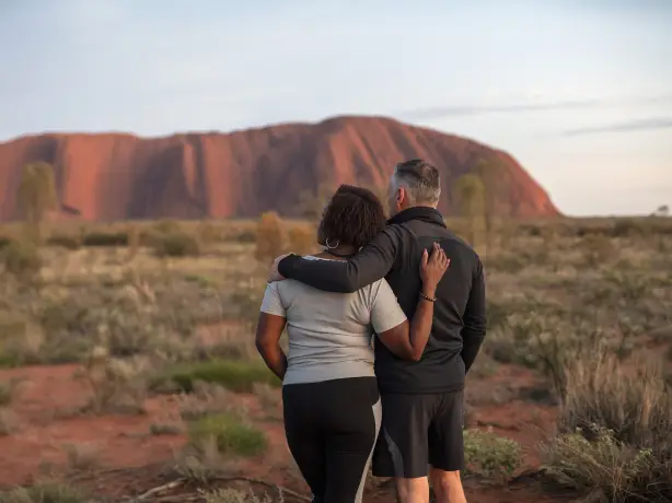 Ein Paar starrt in die Ferne im Uluru National Park, Northern Territory, Australien