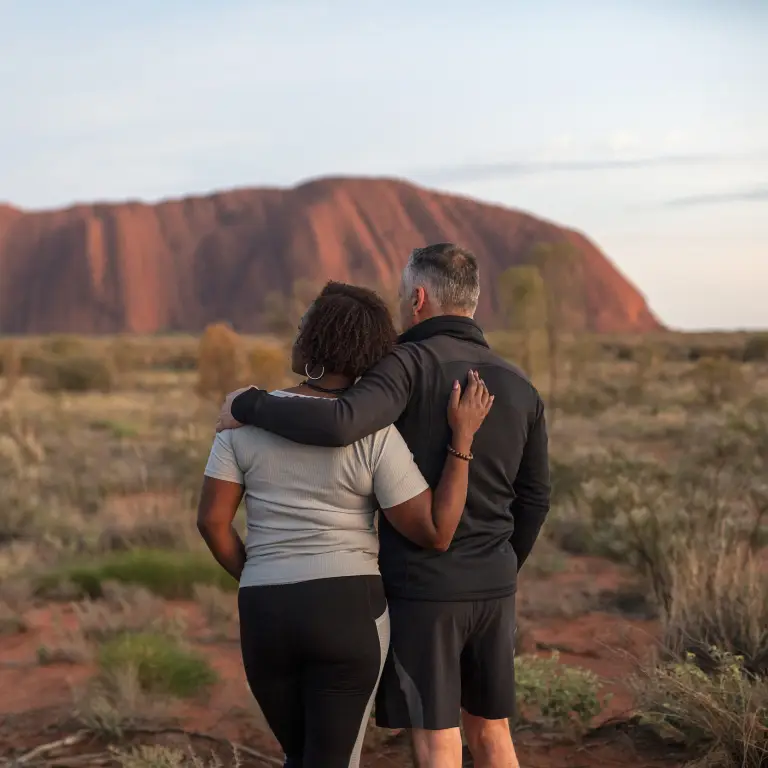Ein Paar starrt in die Ferne im Uluru National Park, Northern Territory, Australien