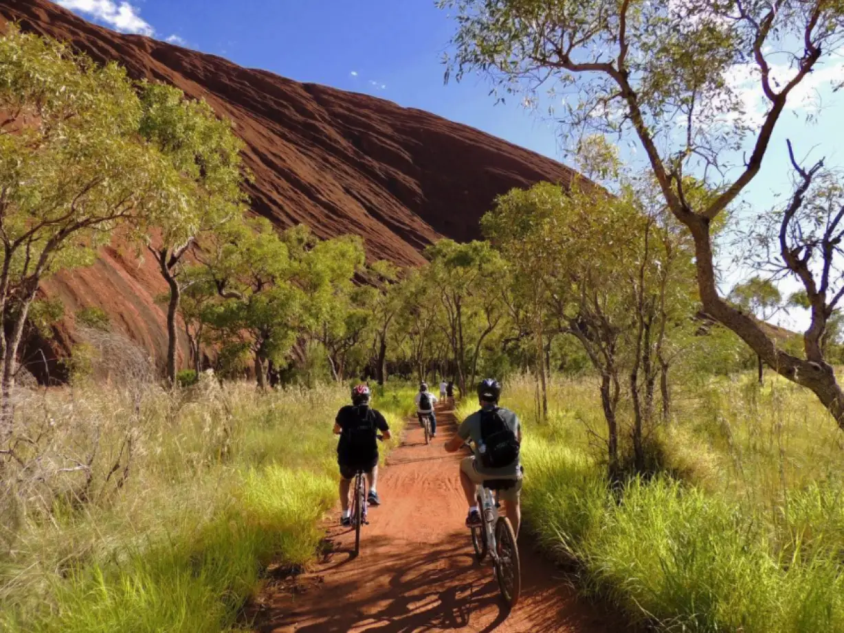 Menschen auf dem Fahrrad im Uluru Outback im Northern Territory, Australien