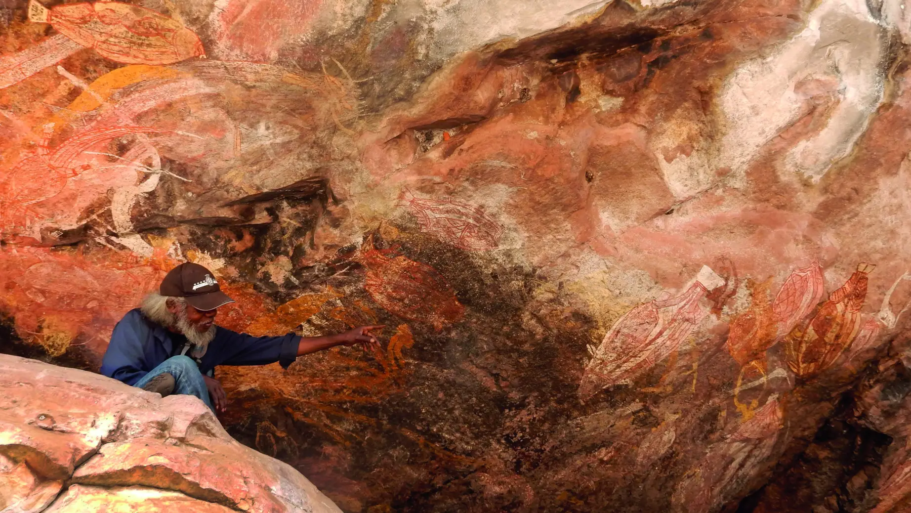 An aboriginal man shows rock art on cultural tour