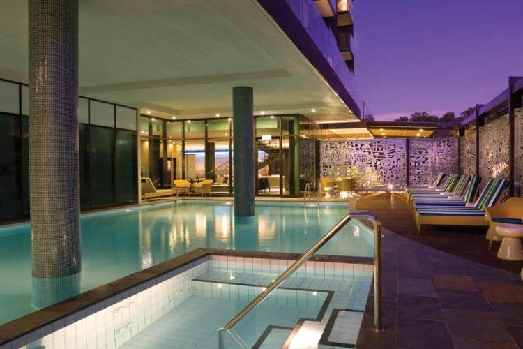 Hotel outdoor pool with loungers at night in Australia