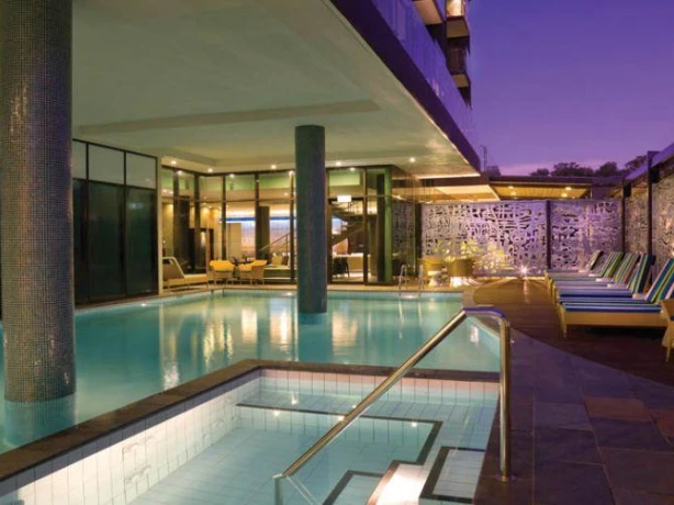 Hotel outdoor pool with loungers at night in Australia
