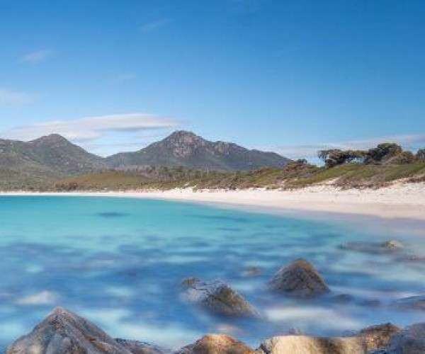 Eine Landschaftsansicht der Wineglass Bay in Tasmanien mit blauem Meer und felsigen Küsten