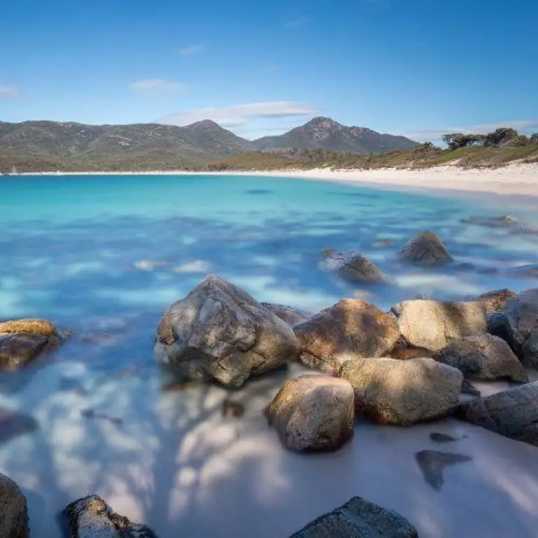 A landscape view of Wineglass Bay in Tasmania with blue seas and rocky shores