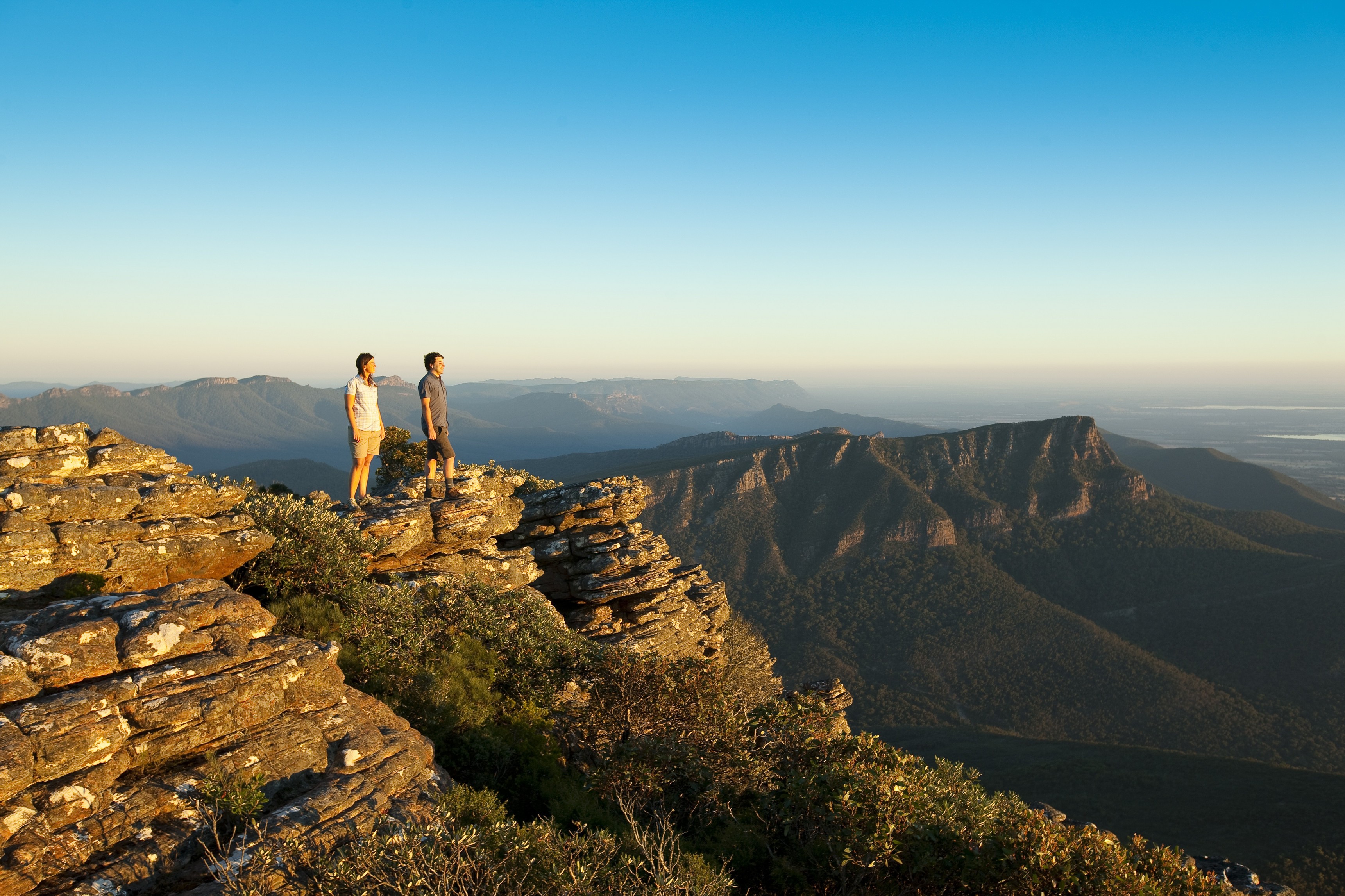 Zwei Menschen stehen auf einem Felsen im Grampians Nationalpark und blicken in die Ferne