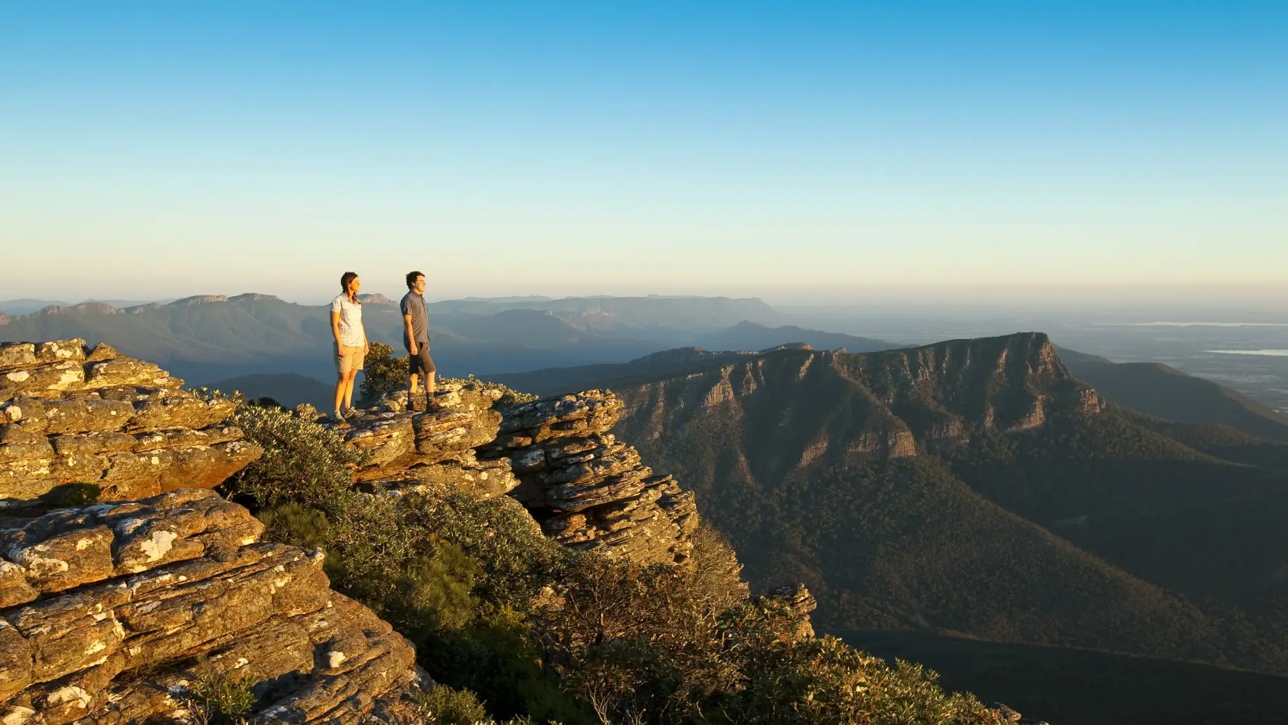 Zwei Menschen stehen auf einem Felsen im Grampians Nationalpark und blicken in die Ferne