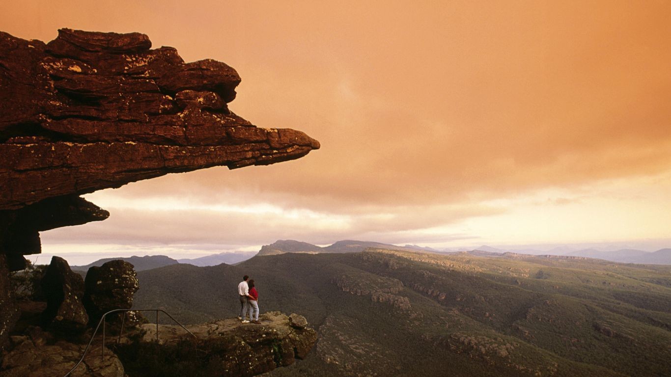 A couple standing on a rock, looking in the distance, in the Grampians National Park in Australia