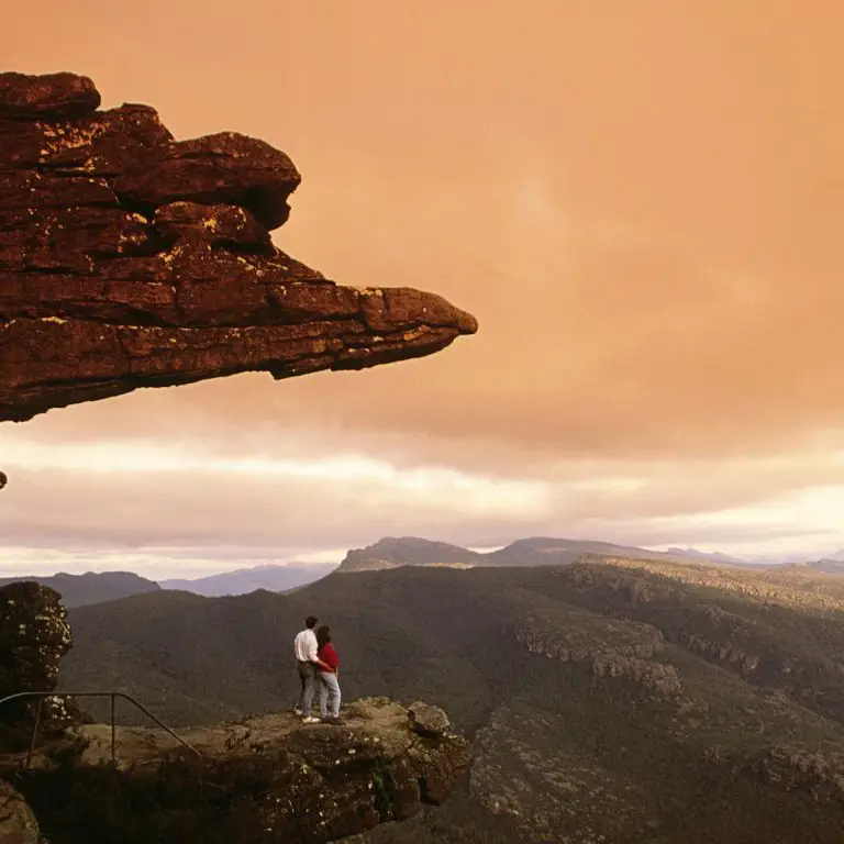 A couple standing on a rock, looking in the distance, in the Grampians National Park in Australia