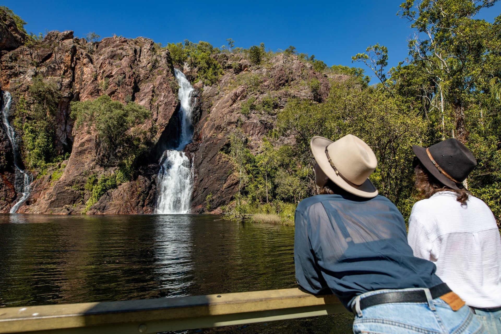 Twee mensen met hoeden, kijkend naar Wangi Falls in het Northern Territory van Australië