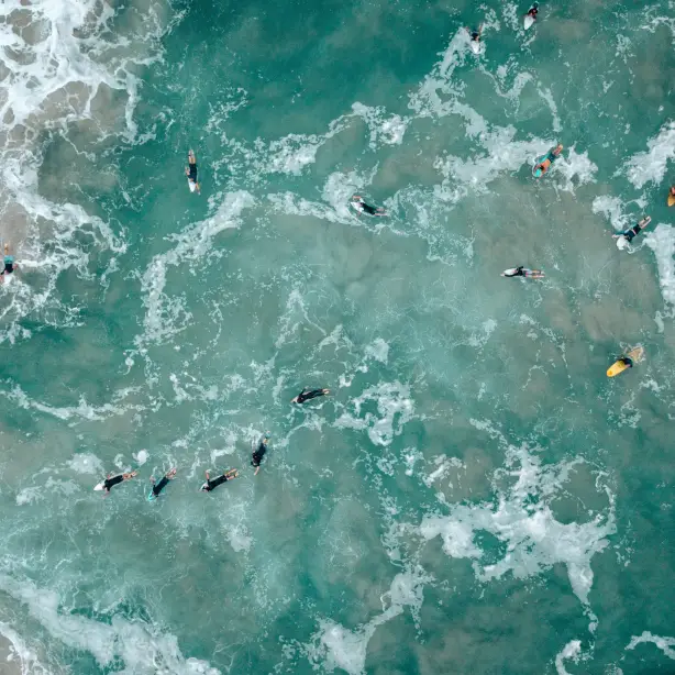 A group of surfers wait for a wave in the ocean in Queensland, Australia