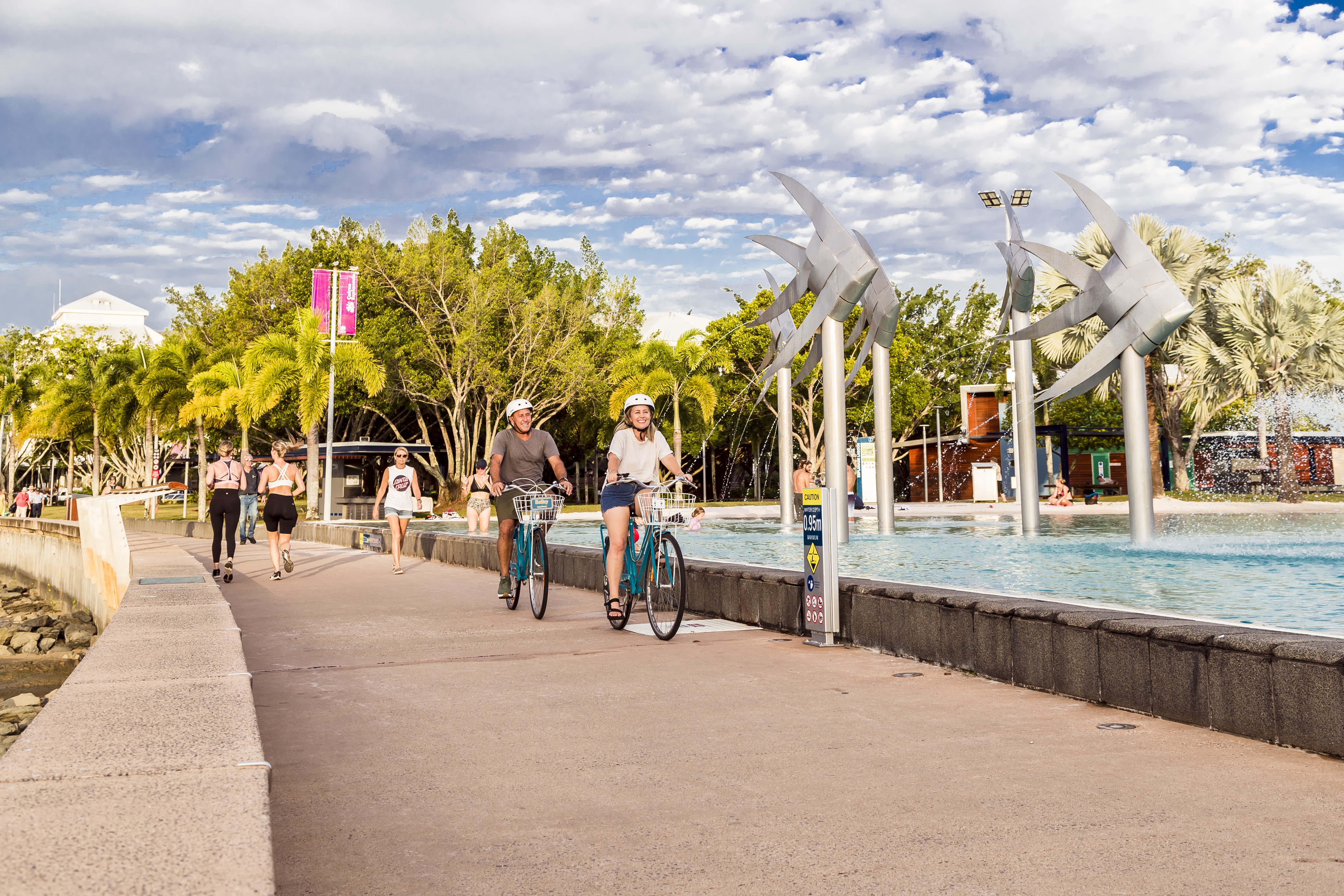 Mensen fietsen en rennen langs de Cairns Esplanade in Australië
