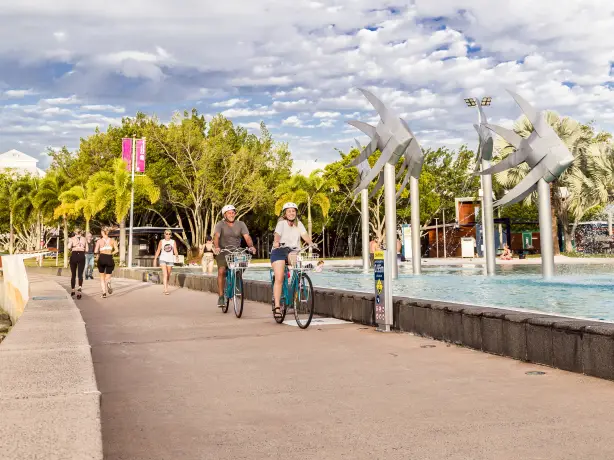 Menschen auf Fahrrädern und beim Laufen entlang der Cairns Esplanade in Australien