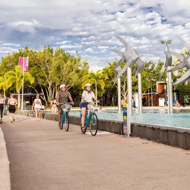 Menschen auf Fahrrädern und beim Laufen entlang der Cairns Esplanade in Australien