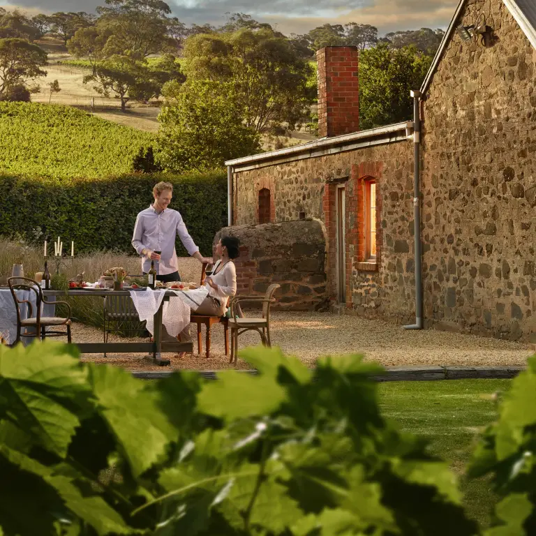 Two people drinking wine and dining outdoors in a Barossa Valley winery in South Australia