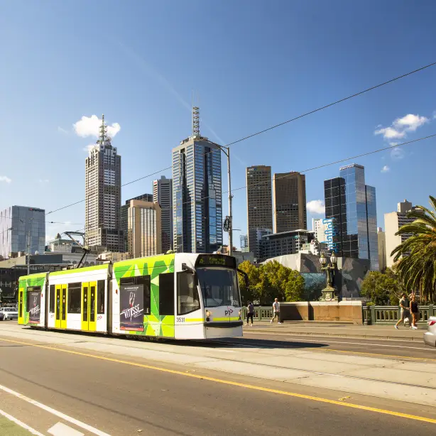 Een tram in Melbourne met de skyline van de stad op de achtergrond