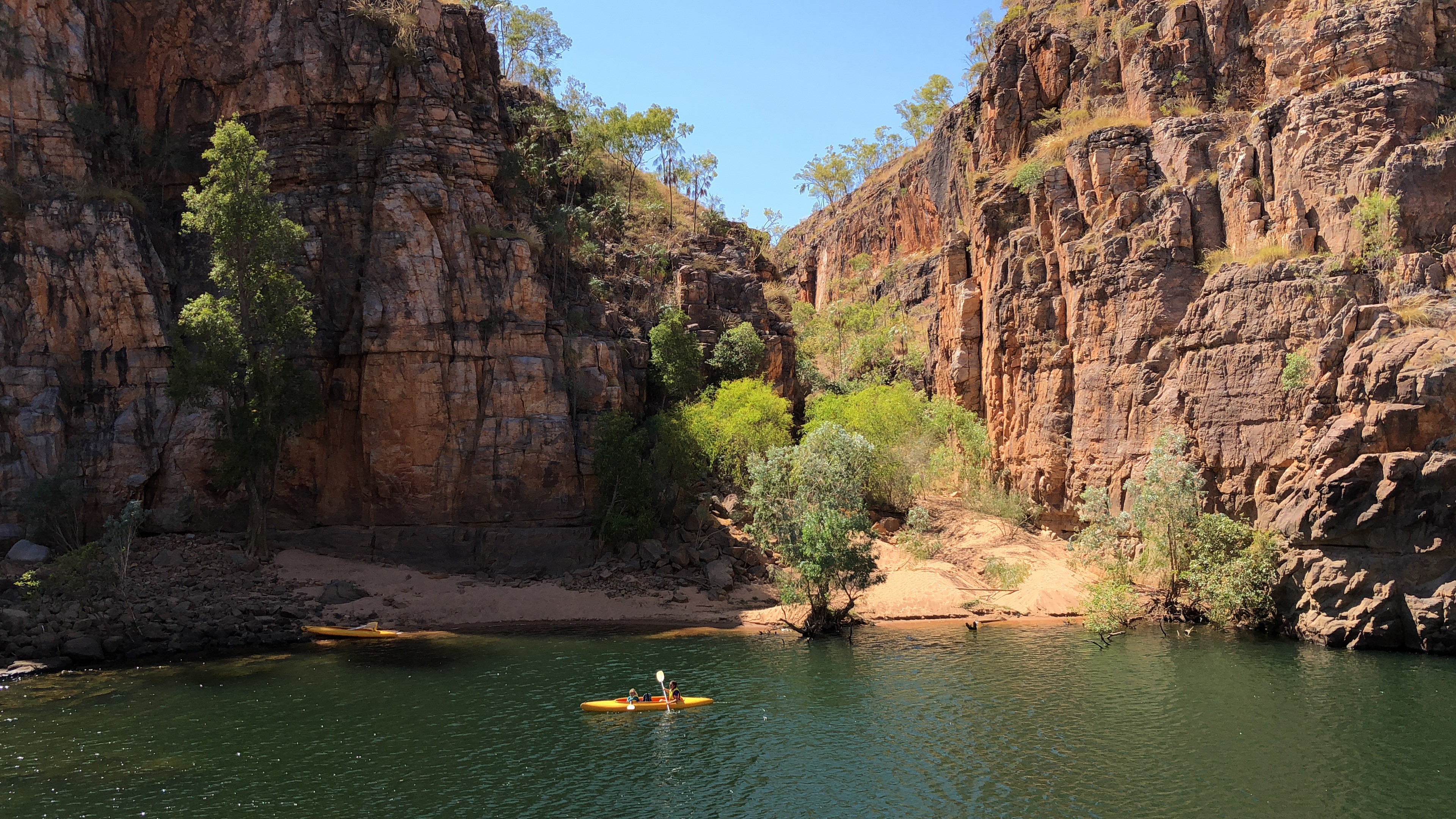 People paddle a yellow kayak on the Katherine River in Nitmiluk National Park, Australia