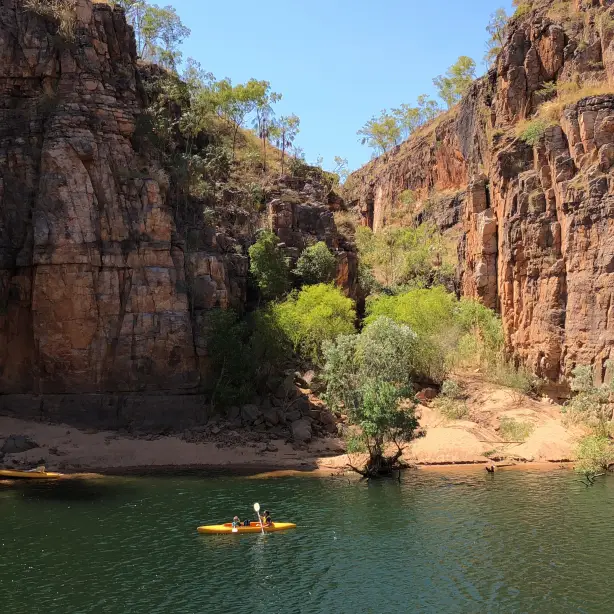 Mensen peddelen in een gele kajak op de Katherine River in Nitmiluk National Park, Australië