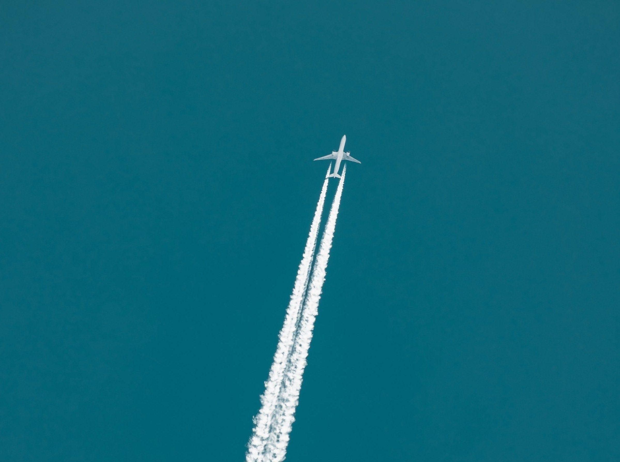 Flugzeug am Himmel mit Kondensstreifen