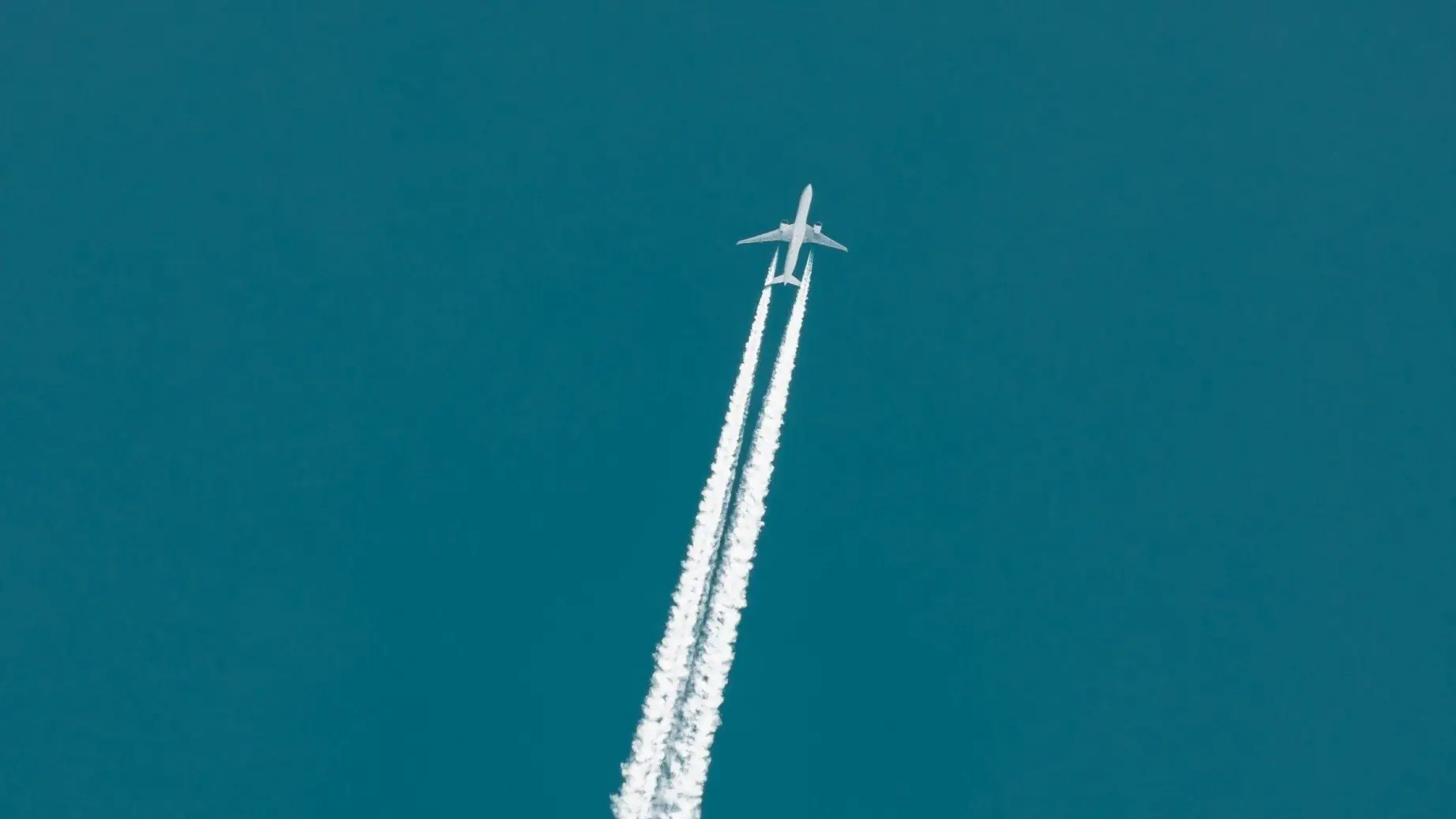 Plane flying through the sky with vapour trails