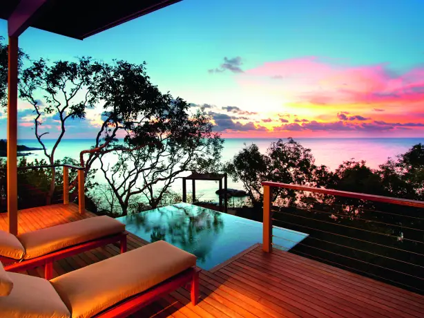 Sun loungers on a terrace overlooking the ocean at sunset