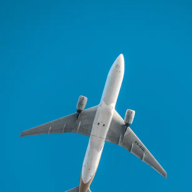 Underside of a plane flying, blue sky in the background