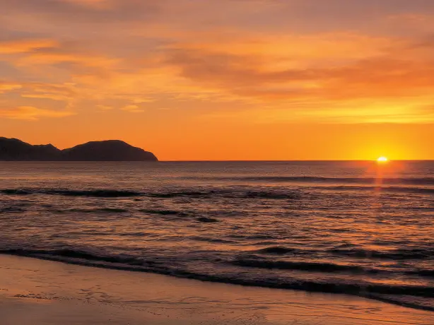 Sonnenaufgang über dem Meer am Wainui Beach in Gisborne Neuseeland
