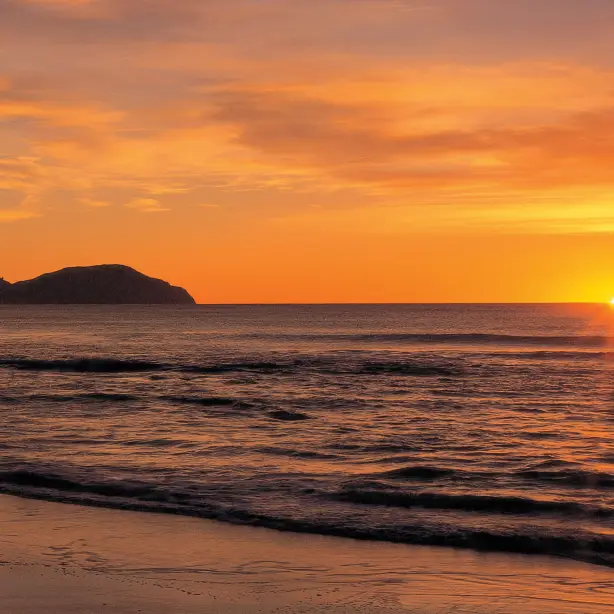 Sonnenaufgang über dem Meer am Wainui Beach in Gisborne Neuseeland