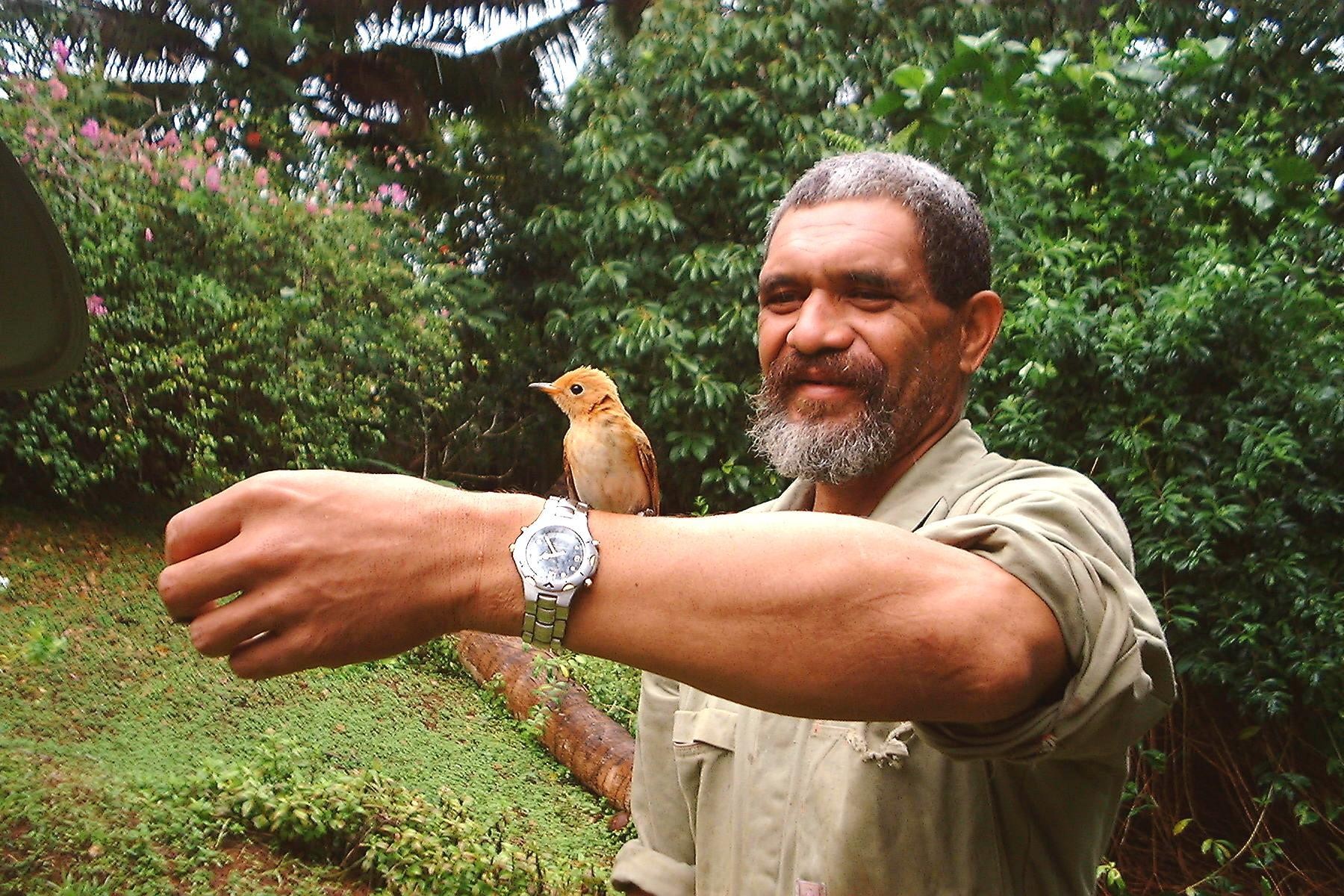 A local guide with a small bird on his arm in Australia