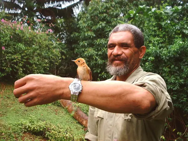 A local guide with a small bird on his arm in Australia