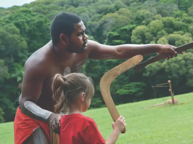 Aborigine-Mann lehrt Kind den Umgang mit einem Bumerang