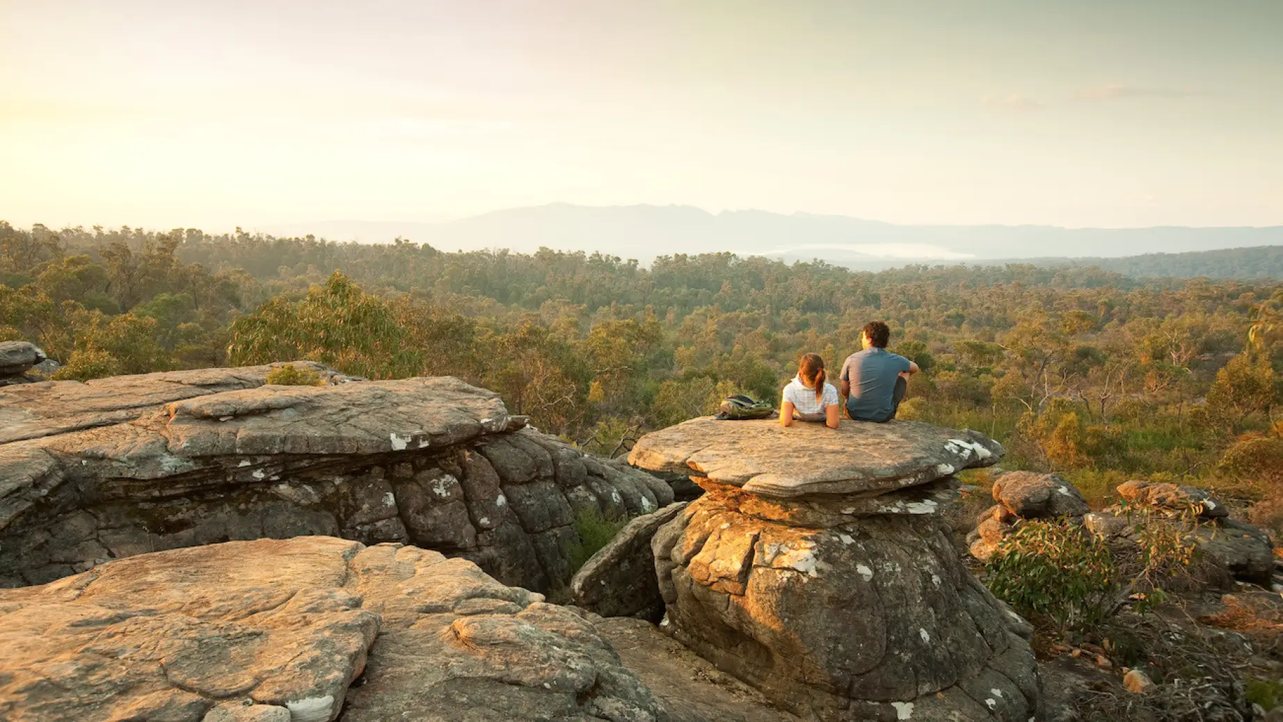 Paar sitzt auf Felsen mit Blick auf den Grampians National Park in Australien