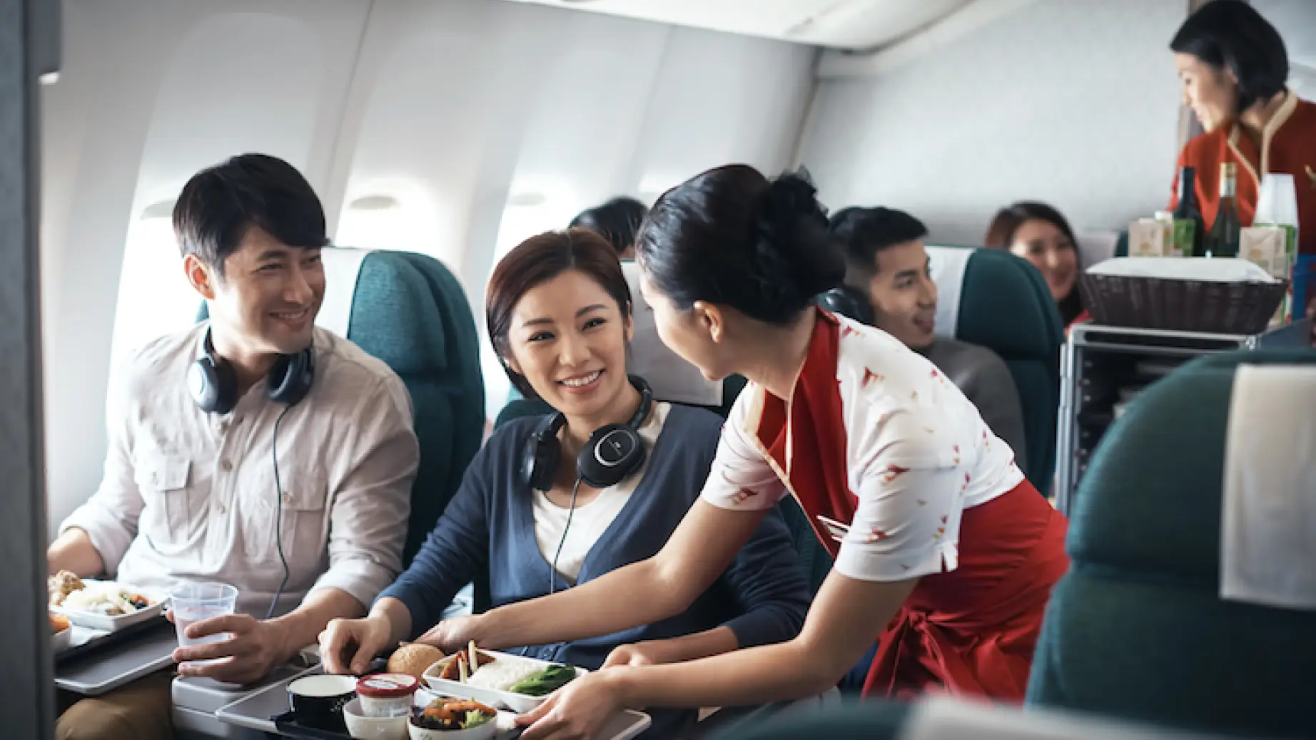 Stewardess der Fluggesellschaft Cathay Pacific serviert Passagieren ihre Mahlzeiten