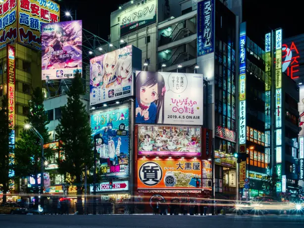 Bright streets of Tokyo at night with large anime billboards