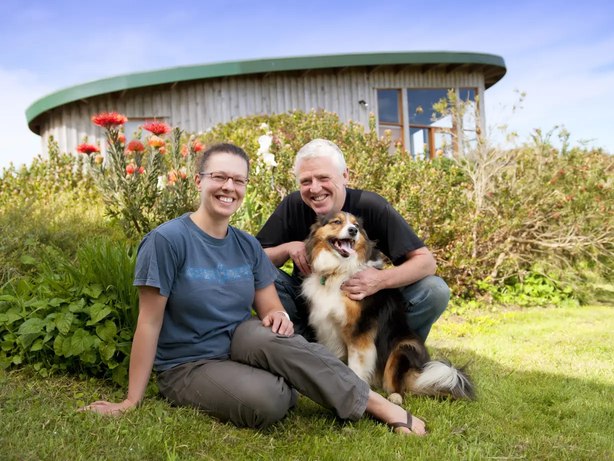 Australien Great Ocean Road Cottage Gastgeber mit Hund lächelnd in die Kamera