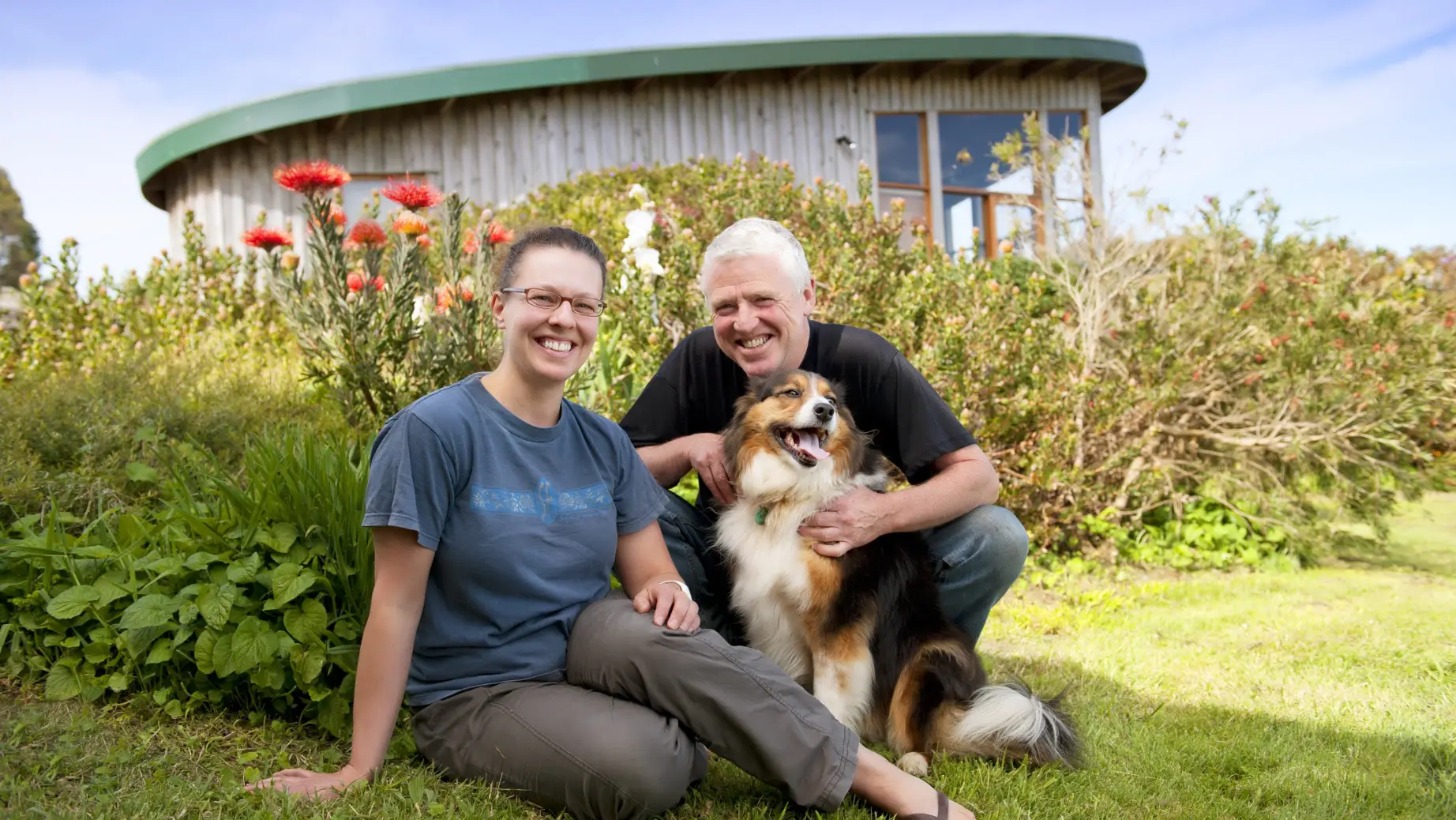 Australien Great Ocean Road Cottage Gastgeber mit Hund lächelnd in die Kamera