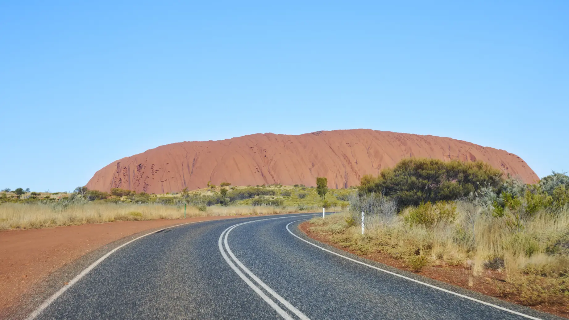 Straße mit Uluru im Hintergrund in Australien