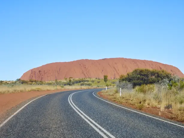 Road with Uluru in the background in Australia