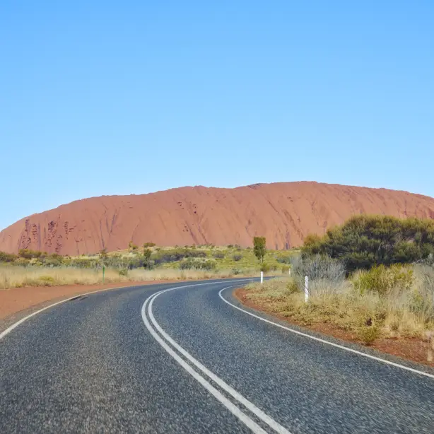 Straße mit Uluru im Hintergrund in Australien