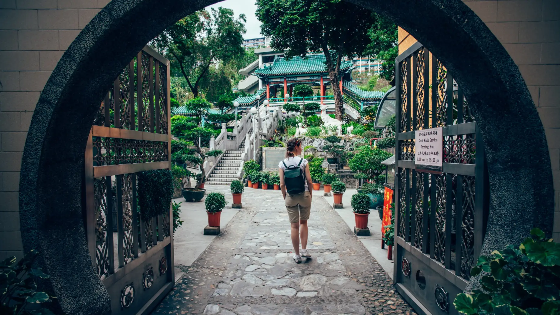 Frau, die durch das Tor des Garten der guten Wünsche in Hongkong geht