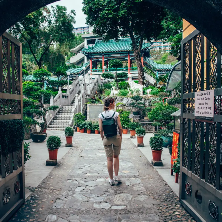 Frau, die durch das Tor des Garten der guten Wünsche in Hongkong geht