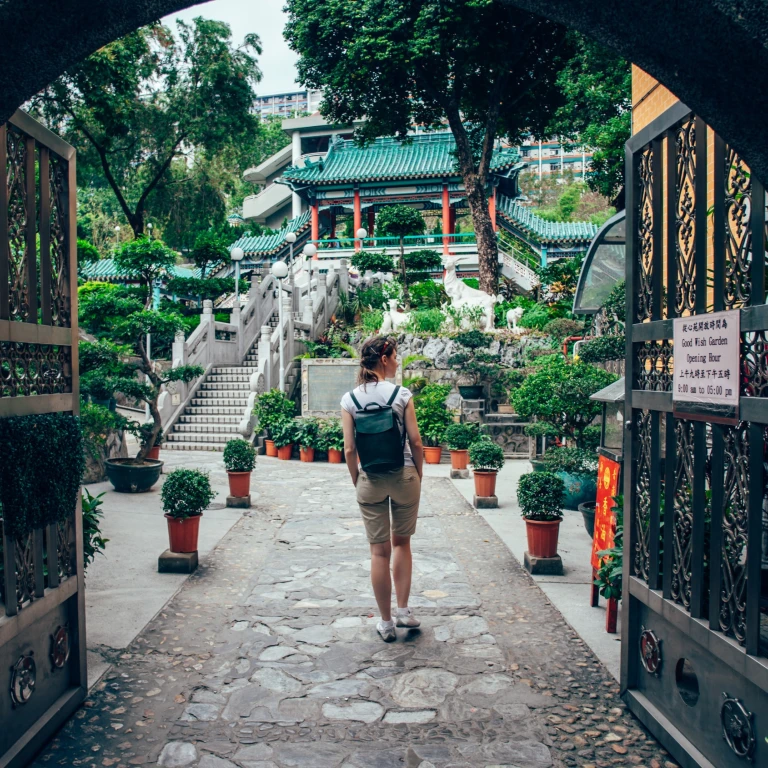 Frau, die durch das Tor des Garten der guten Wünsche in Hongkong geht