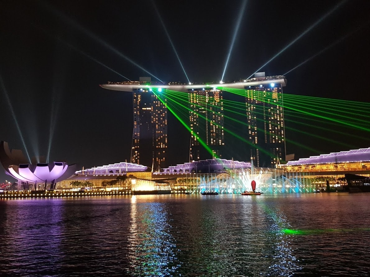 Skyline der beleuchteten Gebäude von einem Fluss bei Nacht in Singapur