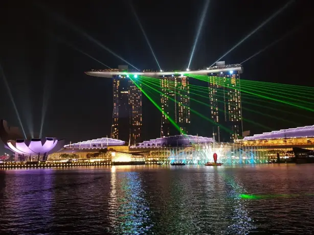 Skyline van verlichte gebouwen vanaf een rivier bij nacht in Singapore