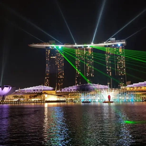 Skyline der beleuchteten Gebäude von einem Fluss bei Nacht in Singapur
