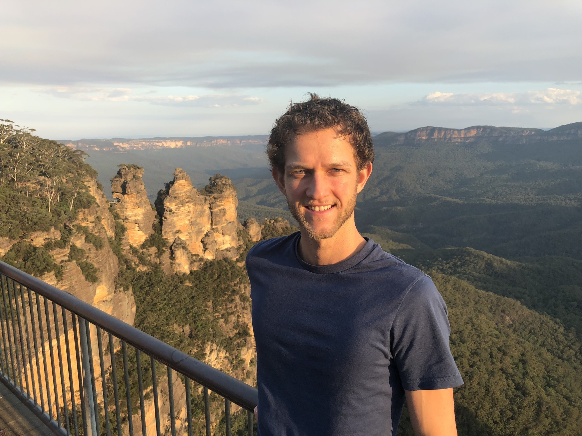 Mann steht am Geländer mit den Three Sisters der Blue Mountains im Hintergrund