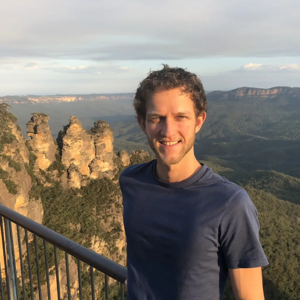 Mann steht am Geländer mit den Three Sisters der Blue Mountains im Hintergrund