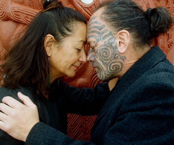 Frau und Maori mit tätowiertem Gesicht beim Maori-Gruß Hongi