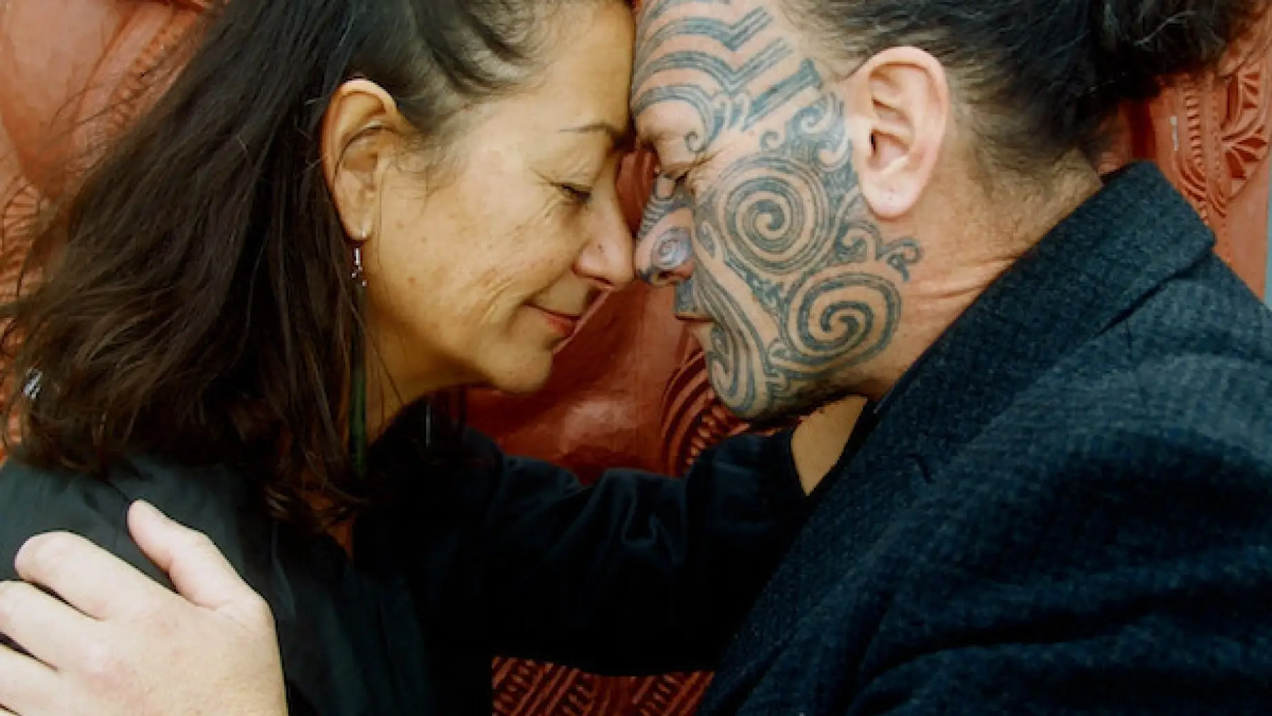 Frau und Maori mit tätowiertem Gesicht beim Maori-Gruß Hongi